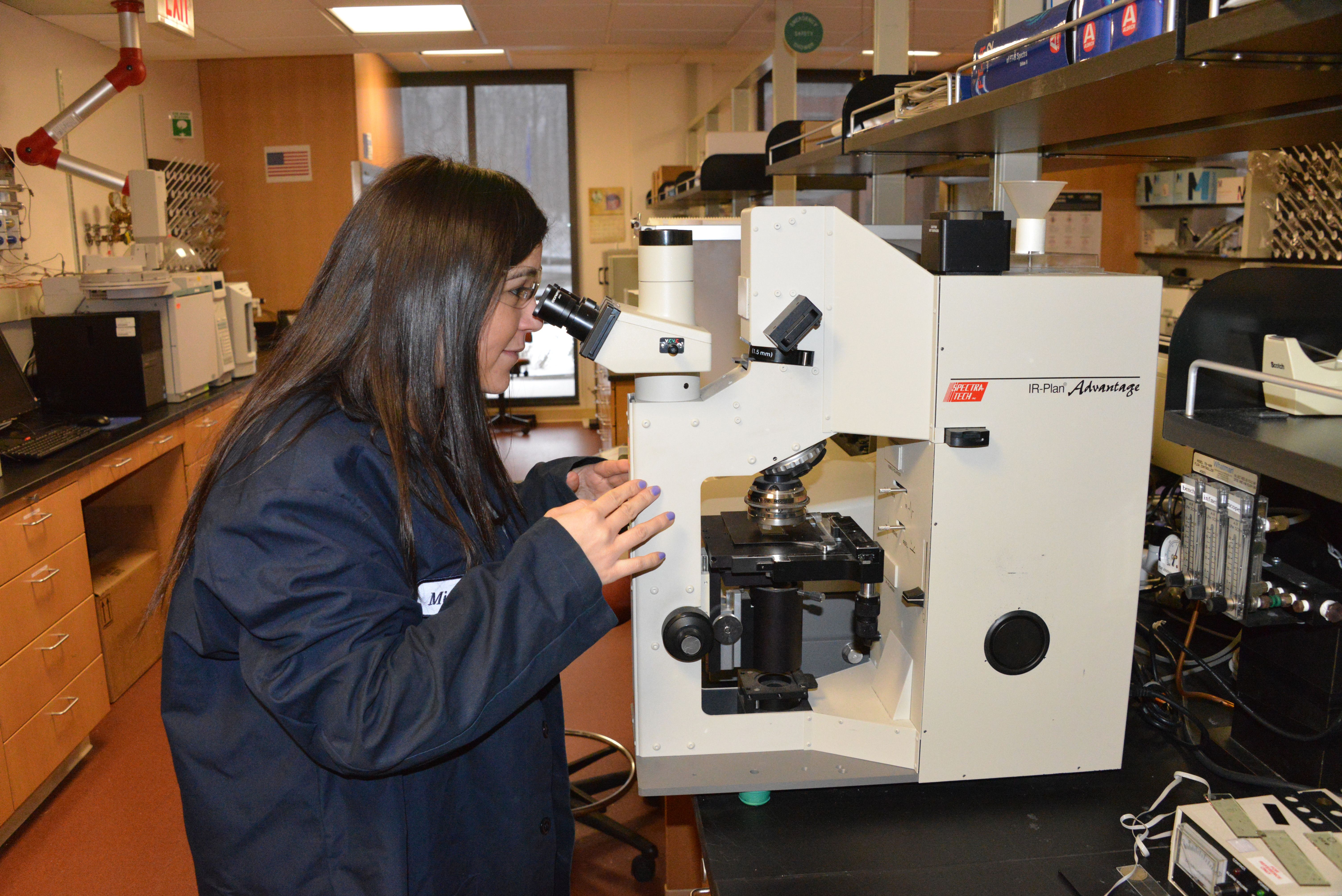 Mujer mirando en un microscopio